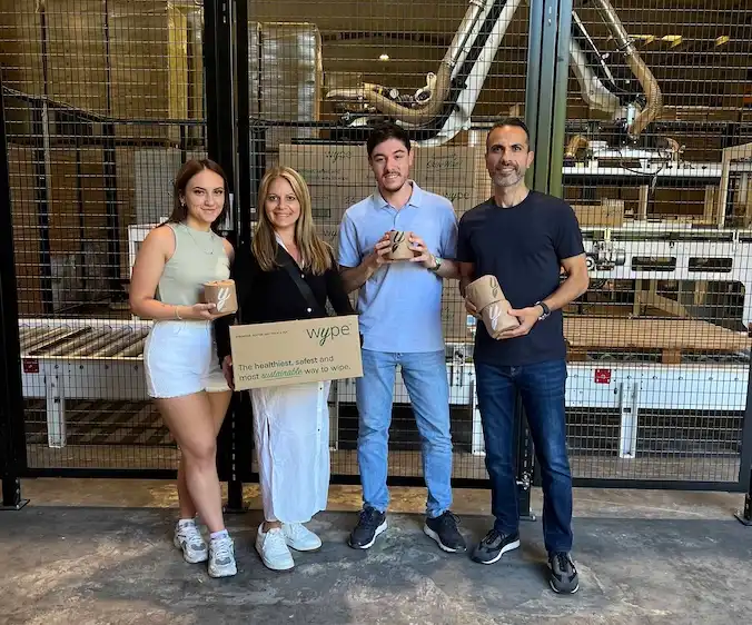 Wype team posing in front of warehouse for assembling Wype toilet paper